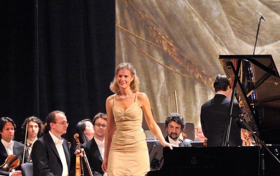 TUM Alumna Sylvia Dankesreiter mit Orchester auf der Bühne.