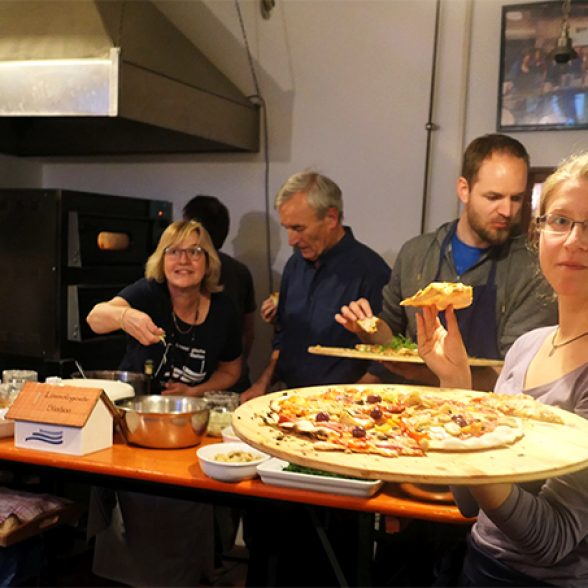 Alumni and employees baking pizza.