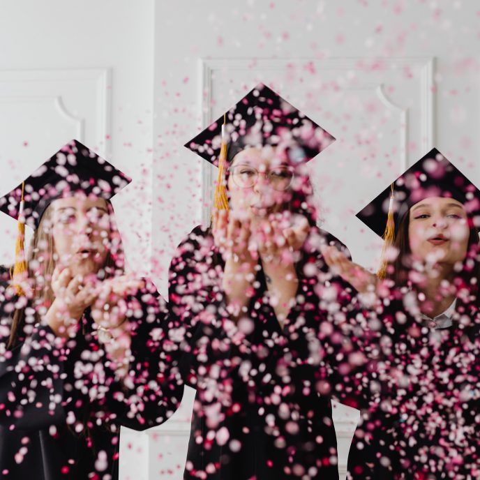 Drei Frauen feiern ihren Abschluss.