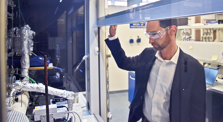 TUM Ambassador Matteo Maestri in front of the Operando Raman Apparatus he developed.