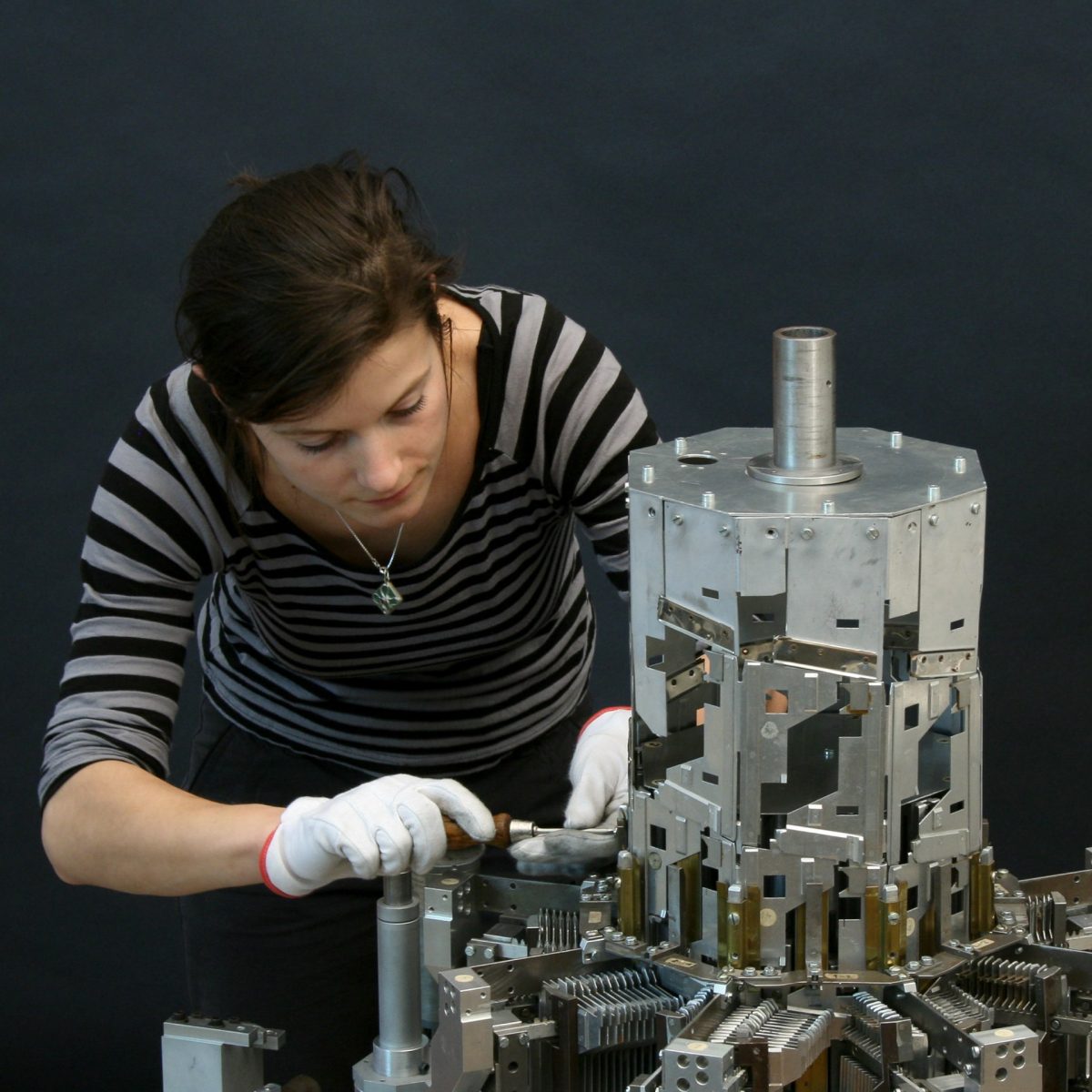 TUM Alumna Dr. Nora Eibisch neben dem Helixturm von Konrad Zuse in der Werkstatt für wissenschaftliche Instrumente des Deutschen Museums.