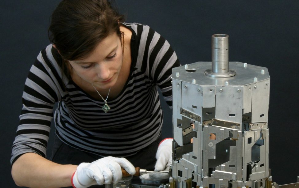 TUM Alumna Dr. Nora Eibisch neben dem Helixturm von Konrad Zuse in der Werkstatt für wissenschaftliche Instrumente des Deutschen Museums.