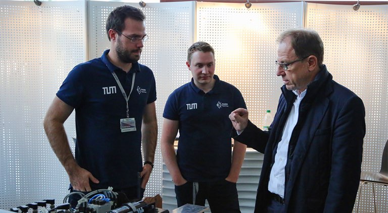 Dr. Reinhard Ploss und zwei Mitglieder des WARR Hyperloop-Teams.