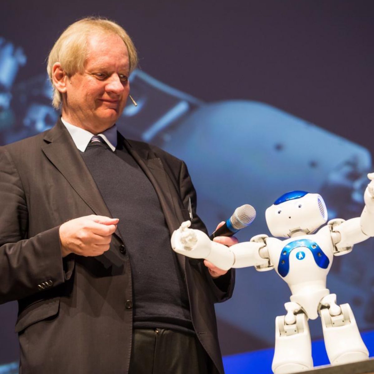 TUM-Alumnus Dr. Ulrich Eberl und Roboter Nao Bluestar.