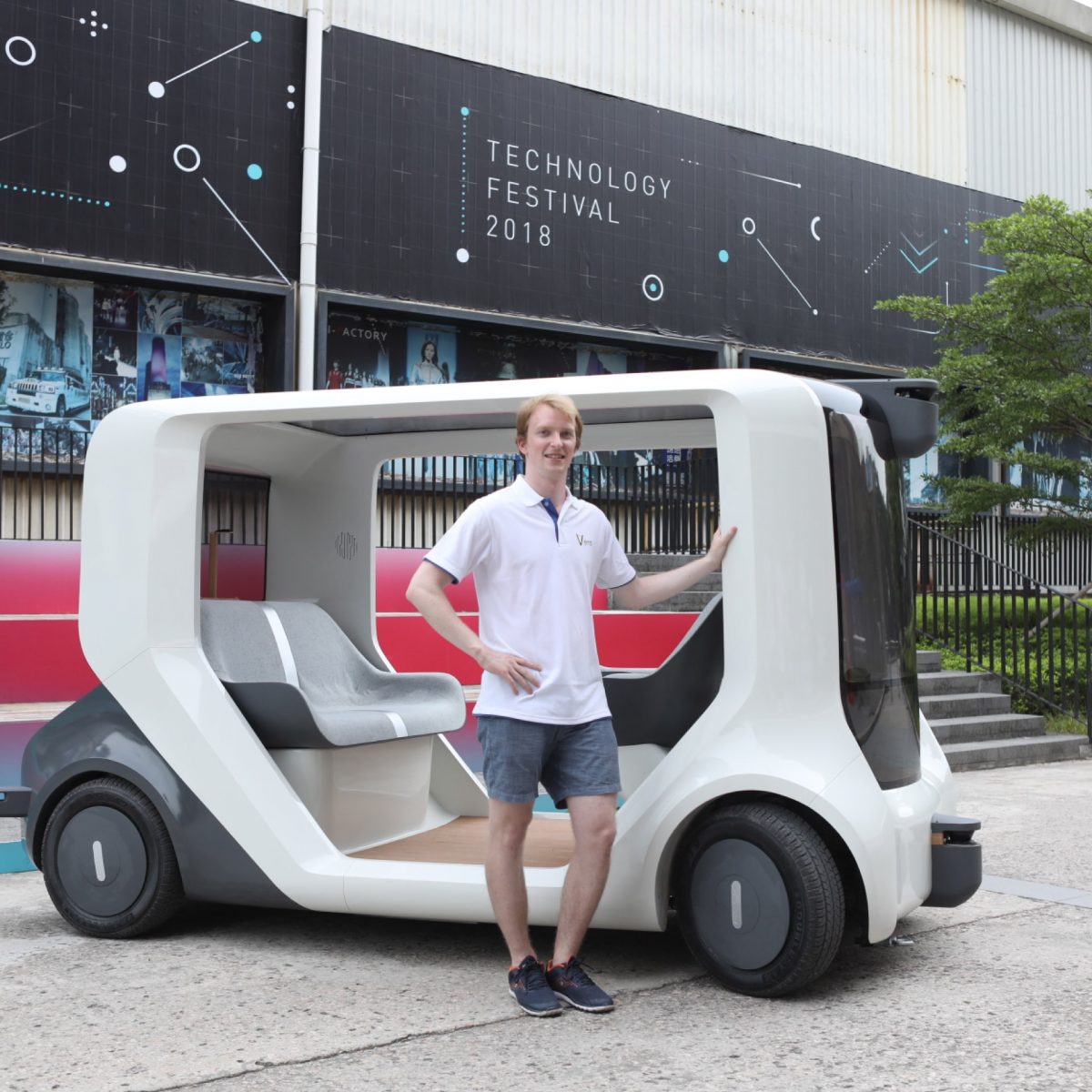 TUM Alumnus Felix Naser mit dem Prototyp des selbstfahrenden weißen Autos.