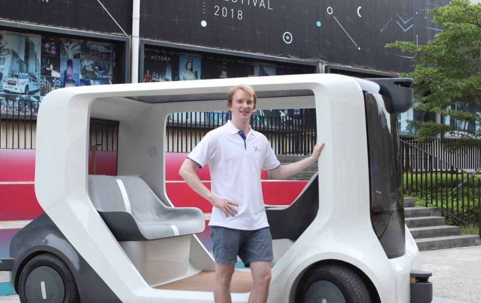 TUM Alumnus Felix Naser mit dem Prototyp des selbstfahrenden weißen Autos.