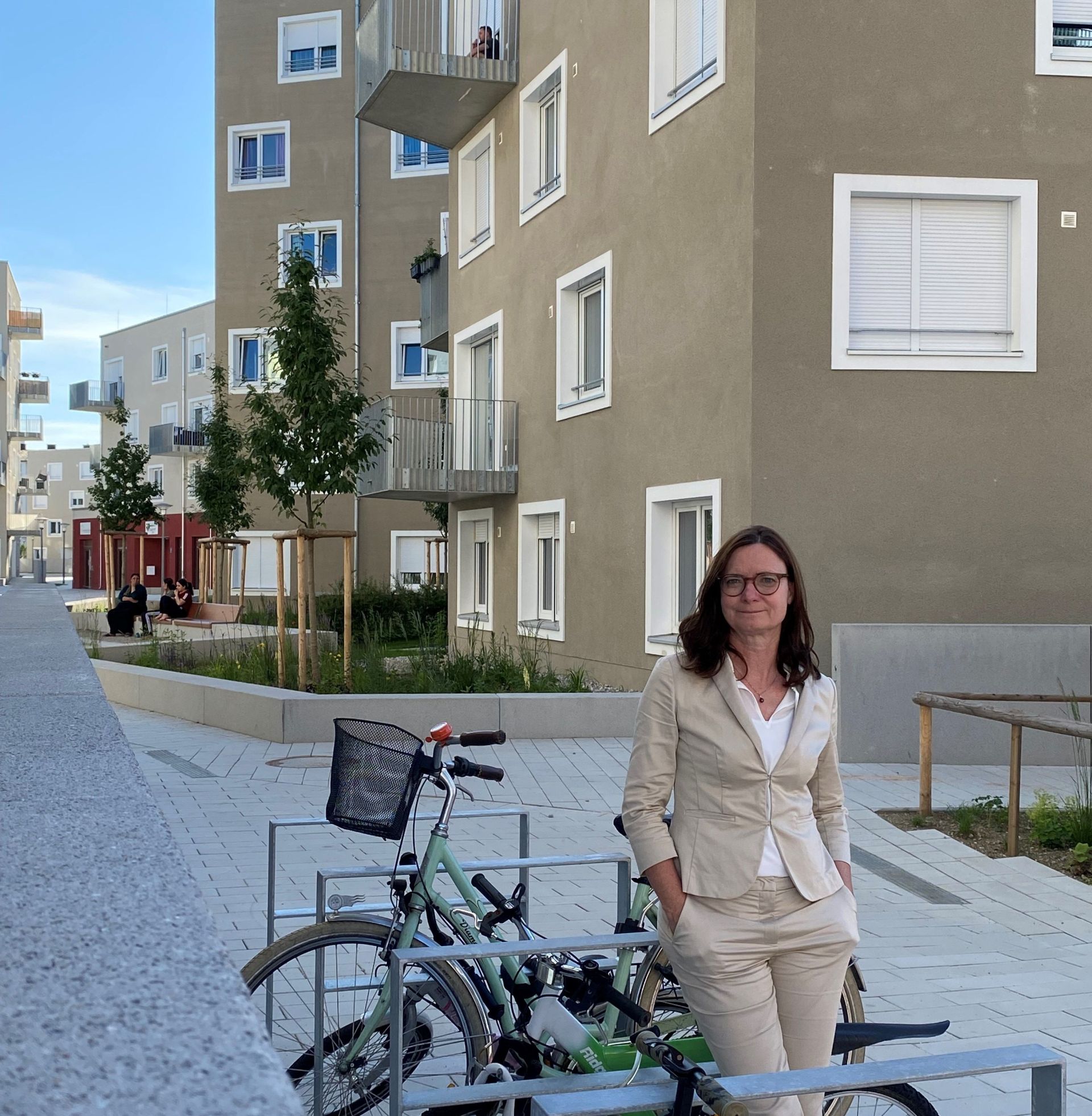 TUM Alumna Doris Zoller in front of a new GEWOFAG building on Ludlstrasse in Munich.