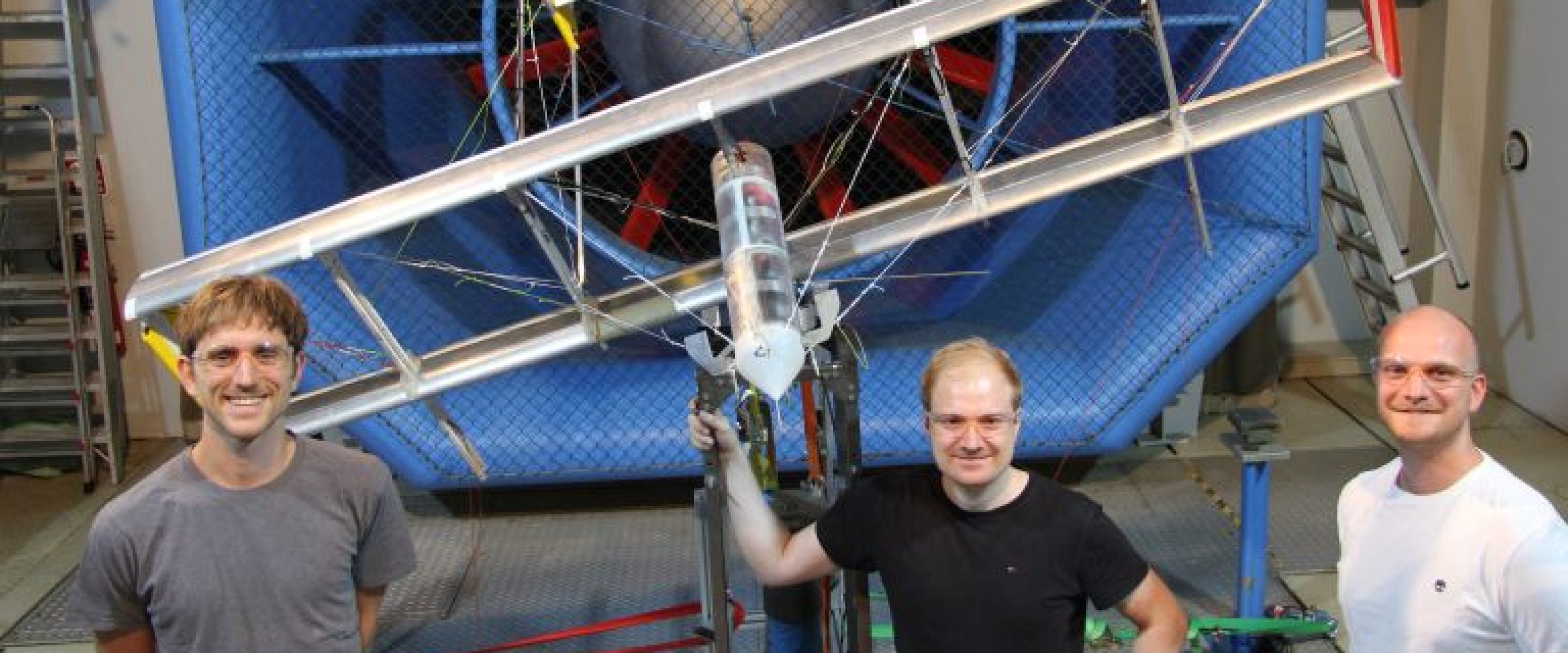 (From left) TUM alumni Christoph Drexler, Florian Bauer and André Frirdich with a kite prototype outside the wind tunnel.
