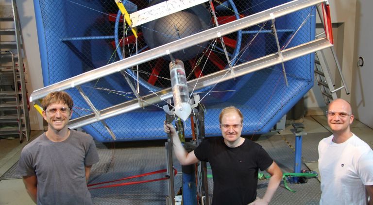 (From left) TUM alumni Christoph Drexler, Florian Bauer and André Frirdich with a kite prototype outside the wind tunnel.