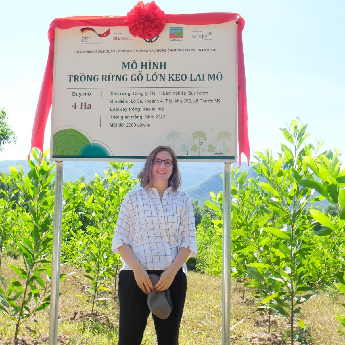 TUM Alumna Carina van Welden vor einem Feld mit jungen Pflanzen.